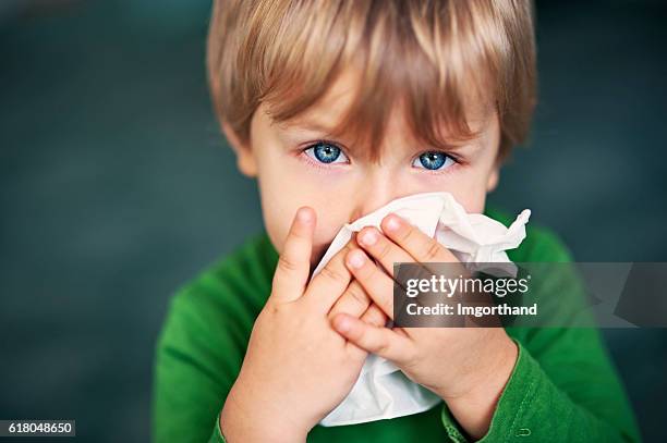 portrait of a sick boy cleaning his nose - cold and flu stock pictures, royalty-free photos & images