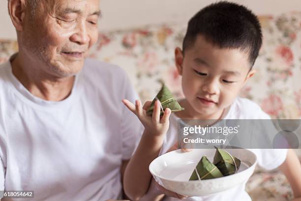 grandfather introducing grandson to zongzi - dragon boat stock pictures, royalty-free photos & images