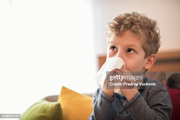 little boy blowing nose - sinusitis stockfoto's en -beelden