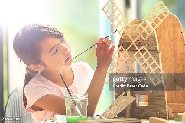 young girl painting wooden windmill - tween girl models stock pictures, royalty-free photos & images