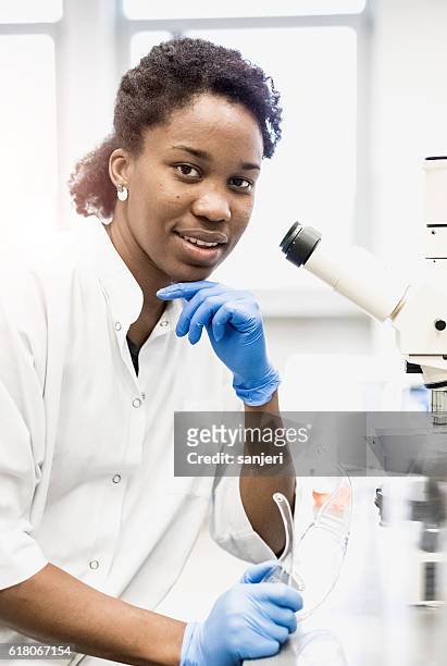 portrait of a scientist beside the  microscope - precision oncology stock pictures, royalty-free photos & images