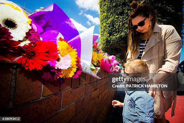 Lara Vincent and her three-year-old son Xavier lay flowers at a makeshift floral tribute at the Dreamworld theme park on the Gold Coast on October 26...