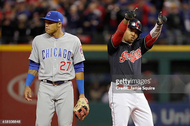 Jose Ramirez of the Cleveland Indians reacts after hitting a double during the sixth inning as Addison Russell of the Chicago Cubs looks on in Game...