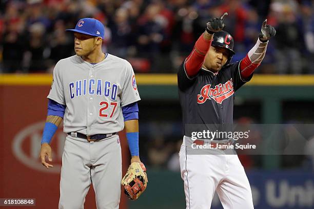 Jose Ramirez of the Cleveland Indians reacts after hitting a double during the sixth inning as Addison Russell of the Chicago Cubs looks on in Game...