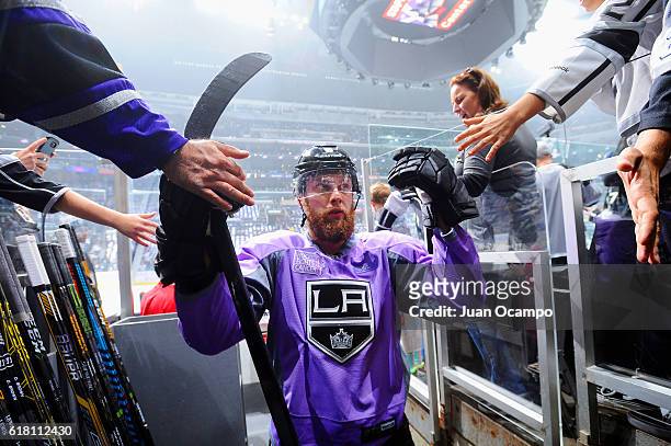 Jake Muzzin of the Los Angeles Kings high-fives fans wearing his Hockey Fights Cancer jersey following warm-ups prior to the game against the...