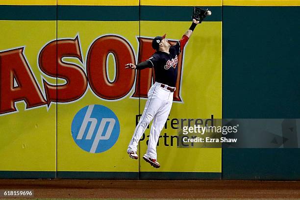 Lonnie Chisenhall of the Cleveland Indians is unable to make a catch on a ball hit by Willson Contreras of the Chicago Cubs in the ninth inning in...