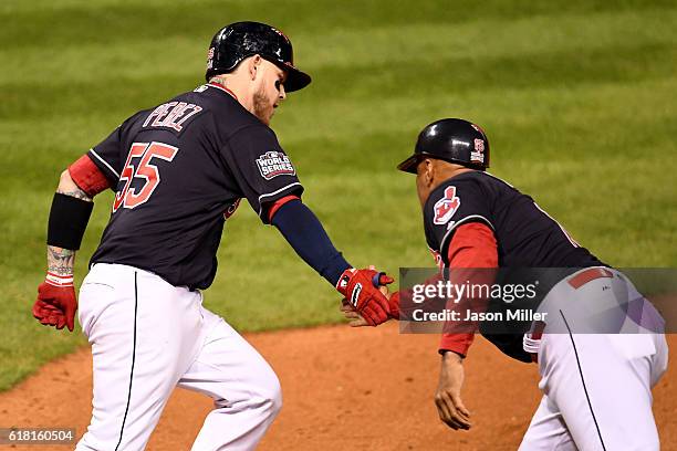 Roberto Perez of the Cleveland Indians high fives first base coach Sandy Alomar Jr. #15 as he runs the bases after hitting a three-run home run...