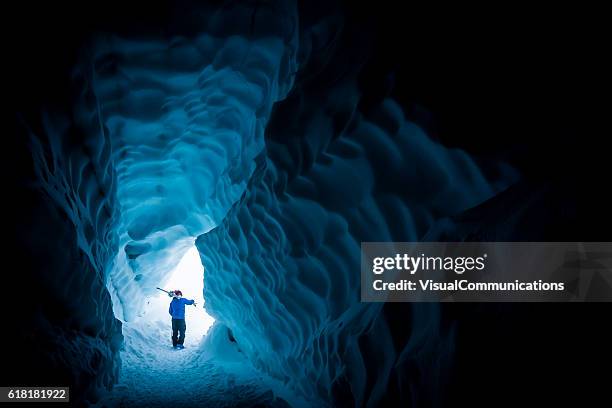 skier exploring ice cave. - ice cave imagens e fotografias de stock