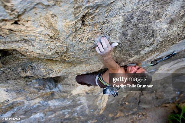 climber on a cliff face - escalada libre fotografías e imágenes de stock