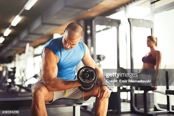 musculaire jeune homme en levant " haltères dans la salle de gym. - musculation des biceps photos et images de collection