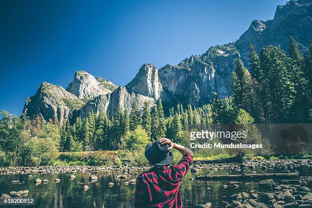 young woman hiking in majestic landscape - woman standing looking down stock pictures, royalty-free photos & images