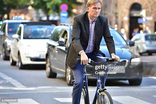 city bicyclist, man in suit, traffic in background, stureplan - stureplan bildbanksfoton och bilder