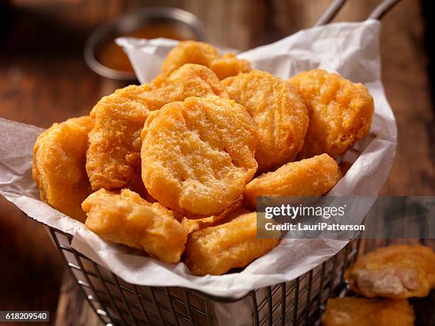 korb mit chicken nuggets mit süßer und saurer sauce - chicken nuggets stock-fotos und bilder