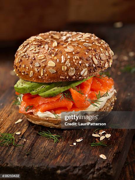 smoked salmon bagel with cream cheese and avocado - brood stockfoto's en -beelden