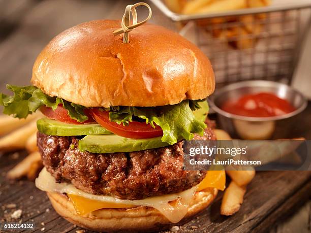 avocado cheeseburger mit einem korb pommes - cheeseburger and fries stock-fotos und bilder