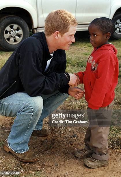 Prince Harry shakes hands with his friend, Mutsu Potsane, in the grounds of the Mants'ase children's home, while on a return visit to Lesotho in...