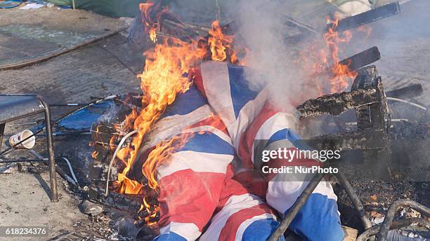 Union Jack burn during eviction of the Calais 'Jungle' camp, in Calais, northern France, on October 25, 2016. French authorities began on October 25,...
