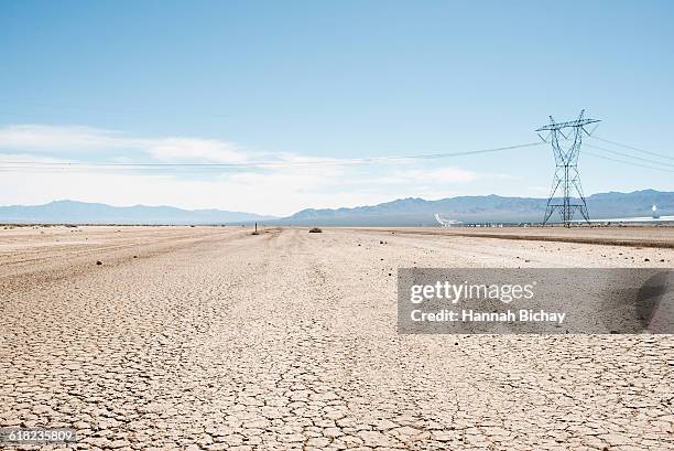 cracked soil in nevada desert with power line - hannah bichay stock pictures, royalty-free photos & images