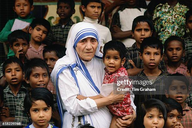 Mother Teresa accompanied by children at her mission in Calcutta, India