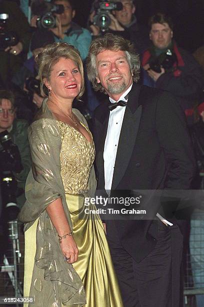 Business entrepreneur Sir Richard Branson in bow tie and tuxedo and wife Joan being photographed at Harrods celebrity charity event