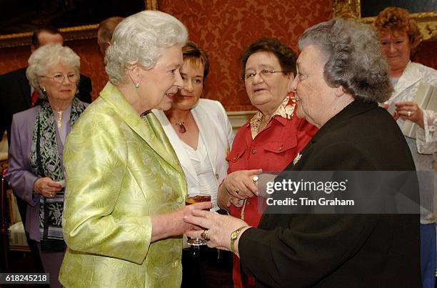 Queen Elizabeth II meets Doreen O'Leary at an 80th birthday lunch held by The Queen at home at Buckingham Palace for 99 guests who will all be...