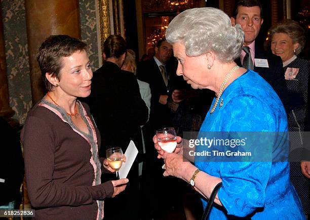 Queen Elizabeth ll holding a drink and talking with Jane Tomlinson during a Pioneer's Reception at Buckingham Palace to celebrate their contribution...