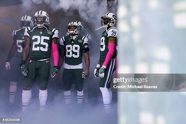 Calvin Pryor, Jalin Marshall and Antonio Allen of the New York Jets look on before taking the field prior to the game against the Baltimore Ravens at...