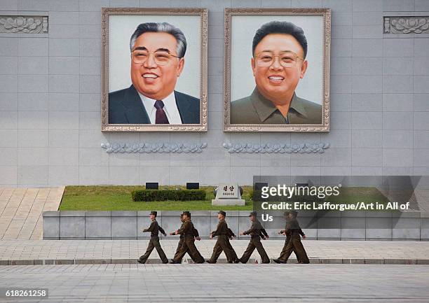 North korean people army soldiers passing in front of kim il sung and kim jong il giant portraits on kim il sung square, pyongyang, North Korea on...