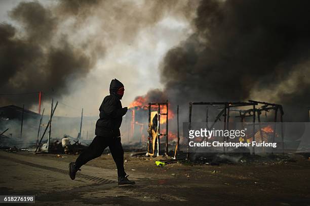 Fire takes hold in the notorious Jungle camp as migrants leave and the authorities demolish the site on October 26, 2016 in Calais, France. Overnight...