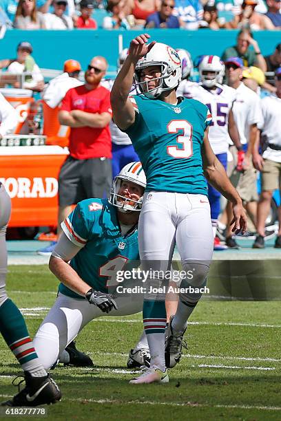 Matt Darr looks up with Andrew Franks of the Miami Dolphins as he kick a field goal against the Buffalo Bills on October 23, 2016 at Hard Rock...