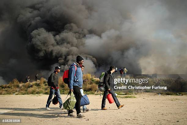 Migrants pack up and leave notorious Jungle camp as authorities demolish the site on October 26, 2016 in Calais, France. Overnight fires broke out in...