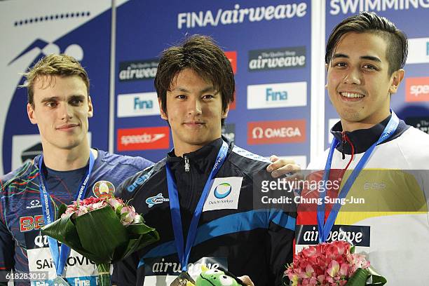 Pavel Sankovich of Belarus, Junya Koga of Japan and Miguel Ortiz-Canavate of Spain pose on the podium after the Men's 50m Backstroke final during the...