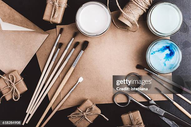 composition with craft paper, paints and brushes on black table with copy space, top view, flat lay. envelope and blank card for holiday message - correspondence stockfoto's en -beelden