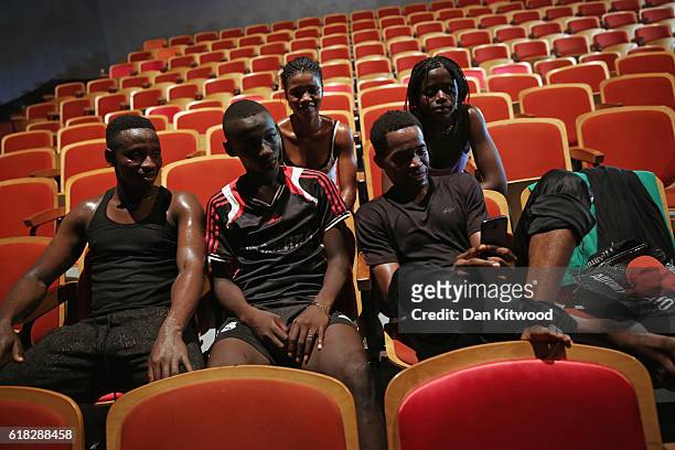 Members of the national dance company of Guinea 'Les Ballets Africains' watch a video of themselves recorded on a phone at the 'Centre of Culture'...