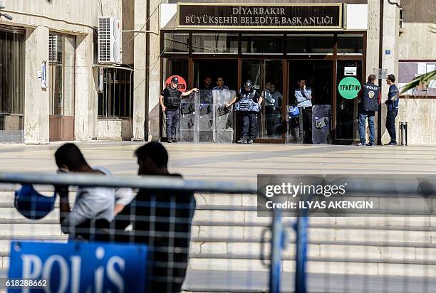 Turkish anti-riot police officers patrol in front of the Diyarbakir municipality headquarters on October 26, 2016 during a demonstration against the...