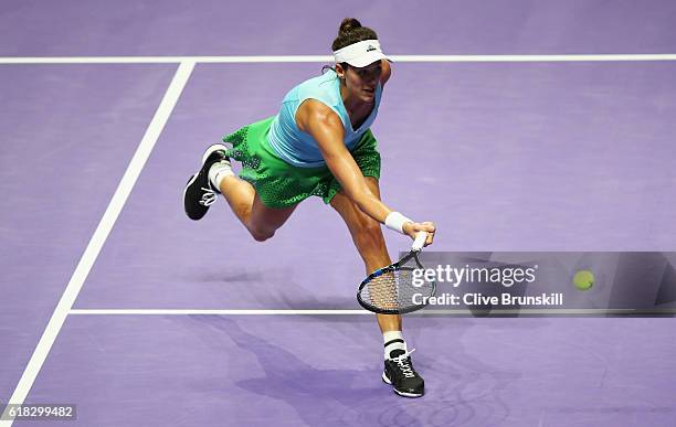 Garbine Muguruza of Spain volleys in her singles match against Agnieszka Radwanska of Poland during day 4 of the BNP Paribas WTA Finals Singapore at...