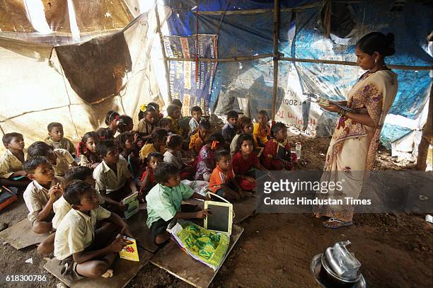Education - School for Ragpickers Children - Kavita Sopane teaches the children of ragpickers the alphabet in their makeshift classroom in Durgawadi...