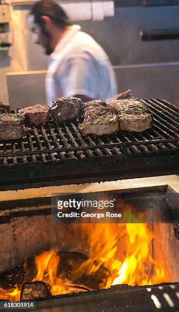 The grillmaster at Jocko's Steakhouse restaurant is shown cooking various cuts of meat on an open flame BBQ on April 13 in Nipomo, California. With...