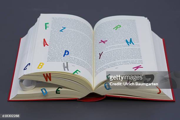 Symbol photo on the topics of education, reading, future of the book, electronic media, computer. The photo shows a opened book with additional...