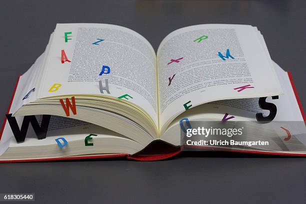 Symbol photo on the topics of education, reading, future of the book, electronic media, computer. The photo shows a opened book with additional...