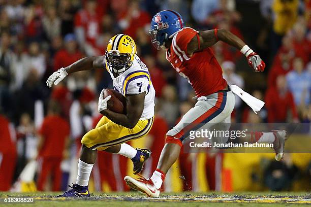 Leonard Fournette of the LSU Tigers runs with the ball as DeMarquis Gates of the Mississippi Rebels defends during a game at Tiger Stadium on October...