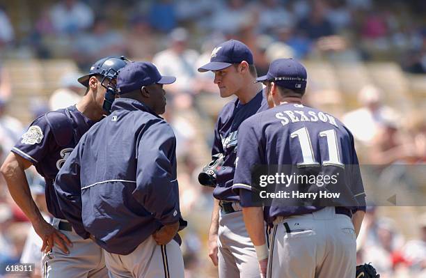 Pitching Coach Dave Stewart of the Milwaukee Brewers talks to pitcher Jamey Wright as teammates first baseman Richie Sexson and catcher Marcus Jensen...