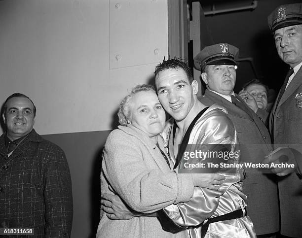 Gene Fullmer celebrates and hugs his mother after winning the middleweight title from Sugar Ray Robinson at Madison Square Garden, New York, New York...