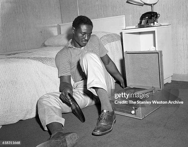 Ezzard Charles is spending time relaxing listening to music after a day of preparing to train for his title fight with Rocky Marciano at Kutsher's...