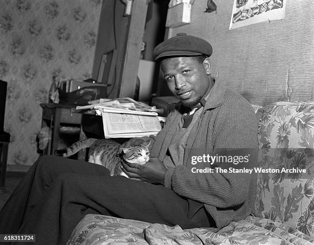 Middleweight champion Sugar Ray Robinson spends some time with his pet cat in Greenwood Lake, New York, November 3, 1956.