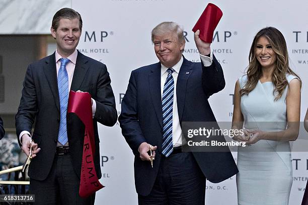 Donald Trump, 2016 Republican presidential nominee, center, holds a piece of ribbon next to his wife Melania Trump, right, and his son Eric Trump...