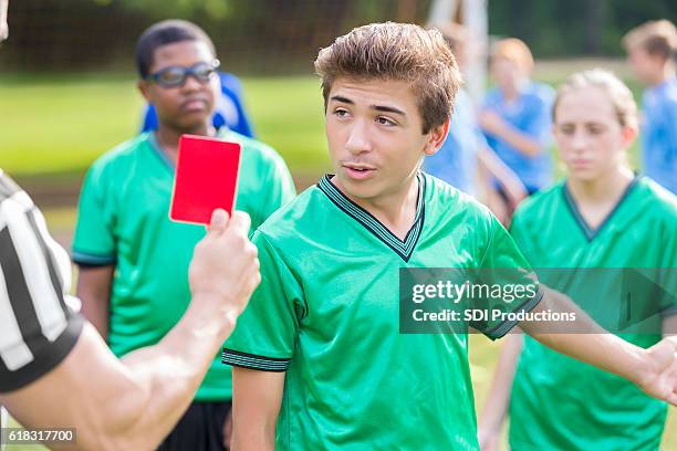 jogador de futebol masculino conversa com árbitro sobre cobrança de pênalti - foul sports - fotografias e filmes do acervo