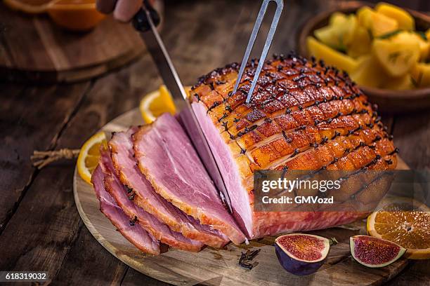 carving glazed holiday ham with cloves - ham imagens e fotografias de stock