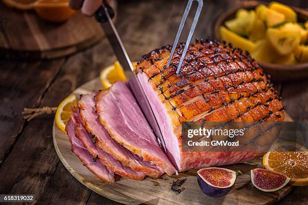 carving glazed holiday ham with cloves - skära mat bildbanksfoton och bilder