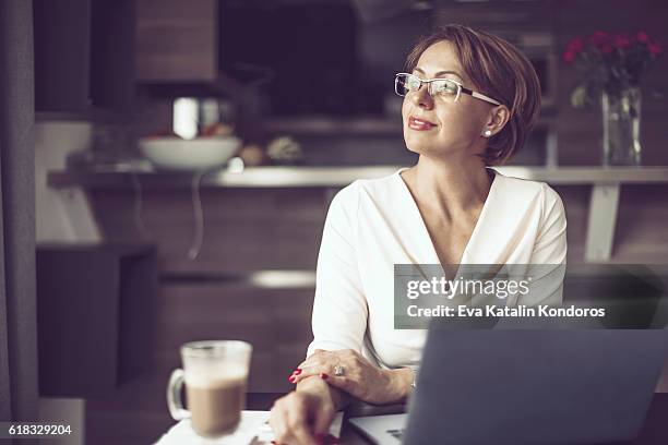 arbeiten at home  - woman portrait kitchen laptop stock-fotos und bilder